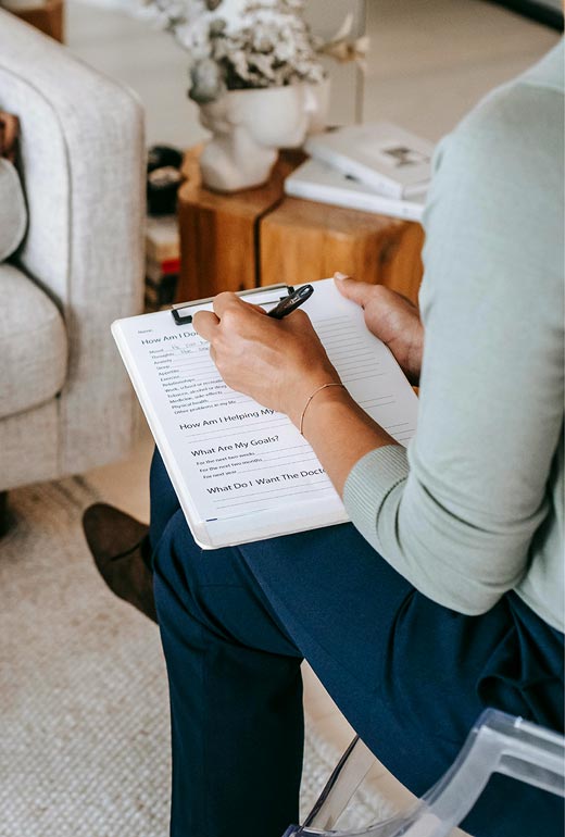 Mentalcoachin macht Notizen während eines Coaching Gesprächs zur Strukturierung von Gedanken und innerer Klärung